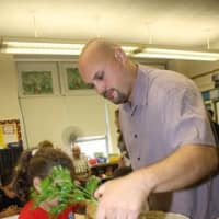 <p>Fifth-grade teacher Dave O&#x27;Neil shows Eastchester students the uses of the sustainability garden.</p>