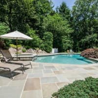 <p>The neatly landscaped backyard includes a stunning pool. </p>