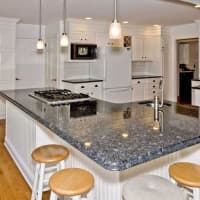 <p>The kitchen features a center island with granite countertops.</p>