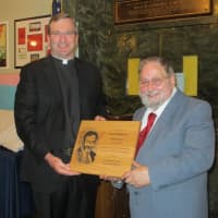 <p>The Rev. Thomas Collins, president of Stepinac High School, presents Ron Tedesco with a plaque for his 50 years at the school.</p>