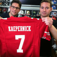 <p>Mark Bisanzo, left, owner of Bruce Park Sports, and Nick Chapar, assistant manager, hold a Colin Kaepernick jersey. Bisanzo said he will wait to see if gay NFL rookie Michael Sam makes his team before deciding whether he will stock the jersey.</p>