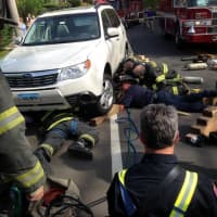 <p>Fairfield and Bridgeport firefighters work together to raise a vehicle in order to pull an injured woman out from under the car.</p>