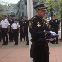 <p>After the retiring of the colors, Lt. James Walsh hands the flag over to Chief Thomas Kulhawik.</p>