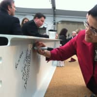 <p>Draupathi Nambudiri, chief of psychiatry at Stamford Hospital, signs a steel beam during an event Wednesday to celebrate a milestone in the construction of the new addition to the hospital.</p>