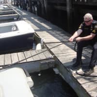 <p>Sgt. Terry Blake helps secure Marine Unit 138 after a trip out in Norwalk Harbor.</p>