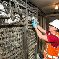 <p>A Metro-North worker repairs damage to a Cos Cob switching house after a fire over the weekend. </p>