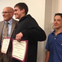 <p>Austin Evans holds both his and his twin brother, Ethan&#x27;s certificates of achievement. </p>