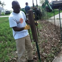 <p>Femi Olowosoyo of Bridgeport drives a post in for new fencing at Sherwood Island State Park on Sunday. At right is Hannah Cruz, a park employee. Olowosoyo was one of the volunteers helping to repair Superstorm Sandy damage at the Westport park.</p>