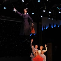 <p>Lauren Blackman as Mary Poppins goes airborne as Joe Dellger (as Mr. Banks), Leisa Mather (as Winifred Banks), Jane Shearin (as Jane Banks) and Gabriel Reis (as Michael Banks) and watch with admiration.</p>