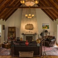 <p>The living room at 229 East Hunting Ridge Road in Stamford has a stone fireplace mantle designed and built by an artist.</p>