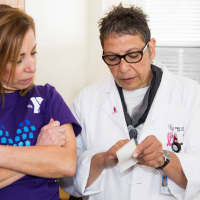 <p>Cindy Rubino looks over test results with a health aide.</p>