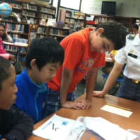 <p>West Point Military Academy cadet Rebecca Lee helps from left: Matthew Midy, Andrew Fang and Tyler Brown during robotics event Tuesday at Cloonan Middle School to encourage students interest in engineering, math and science </p>