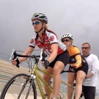 <p>Amy Dixon and Lindsey Cook get assistance at the start of a practice ride.</p>