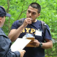 <p>Student Jorge Reyes gets debriefed by a New Rochelle police officer in the New Rochelle High School forensics class immersive final. </p>