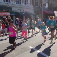 <p>Runners sprint as they approach the finish of the Hope in Motion Walk and Run in Stamford.</p>