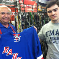 <p>Instant Replay Sports employees Len Gambino, left, and Taylor Considine, hold up a New York Rangers jersey at the store on Monday. Both men are hoping the Rangers will win the Stanley Cup. </p>