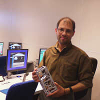<p>The Discovery Museum&#x27;s Director of Space Science Education David Mestre holds a replica of the CubeSat, which he helped to design. </p>