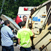 <p>Volunteers bring trash to dispose of in the garbage truck. </p>