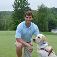 <p>Eli Manning poses for photos with Jansen, a male yellow Labrador who is a guide dog in training.</p>