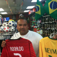 <p>Maynor Gonzalez, owner of Soccer Land, holds up the jerseys of Portugal&#x27;s superstar Ronaldo and Brazilian favorite Neymar. The World Cup begins Thursday, and Gonzalez believes host Brazil and Germany are the favorites to win.</p>