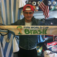 <p>Maurice Cabrera, 26, from Port Chester, N.Y., holds an Argentina jersey and a World Cup scarf at Soccer &amp; Rugby Imports at 42 W. Putnam Ave., Wednesday. The World Cup begins Thursday in Brazil.</p>