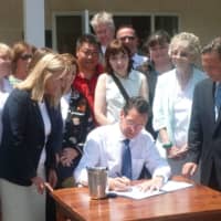 <p>Surrounded by state politicians and animal advocates, Gov. Dannel P. Malloy, signs a new animal protection law in Greenwich on Wednesday.</p>