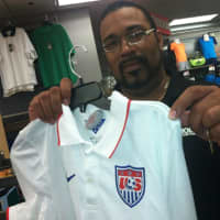 <p>Modell&#x27;s manager Wilfredo Carrasco holds up the &quot;home&quot; jersey for the U.S. World Cup team. He said sales of American jerseys and other gear has been strong, especially the more colorful &quot;away&quot; jersey that he said has been a strong seller.</p>