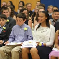<p>A student smiles at her family after her row received their certificates.</p>