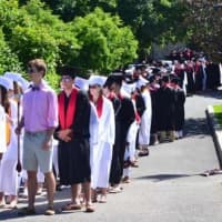 <p>Graduates prepare to walk into the ceremony. </p>