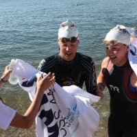 <p>Swimmers get a warm greeting from volunteers after the chilly swim.</p>