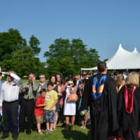 <p>Somers school officials walk on a red carpet to the graduation tent.</p>