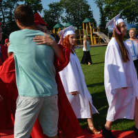 <p>A Somers High School Class of 2014 member gets a hug on the way to the graduation tent.</p>