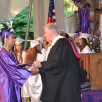<p>A John Jay High School 2014 graduate receives his diploma.</p>