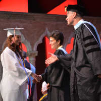 <p>A Fox Lane High School graduate walks on stage during the presentation of diplomas.</p>