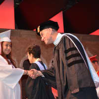 <p>A Fox Lane High School graduate walks on stage during the presentation of diplomas.</p>