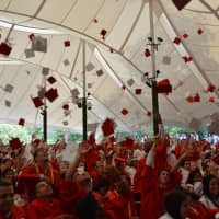 <p>Celebrating members of Fox Lane High School&#x27;s 2014 graduating class throw their caps into the air.</p>