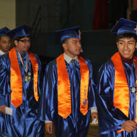 <p>Male students line up to receive their diplomas.</p>