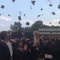 <p>Seniors toss their caps after receiving their diplomas Wednesday on the Mamaroneck High School baseball field. </p>