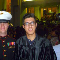 <p>Charly Mejia gets congratulated on graduating high school by Stout Sgt. Christopher Pratt of the U.S. Marines. </p>