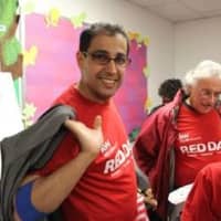 <p>Jamal Hadi, left, Principal Broker of Keller Williams Realty in Scarsdale and the Bronx smiles broadly at his teams Red Day community service activities.</p>