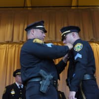<p>New Sgt. Michael Paris is given his new badge by his father, a sergeant in the Bridgeport Police Department. </p>