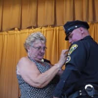 <p>Detective George Buckmir hashis new badge presented by his mother. </p>