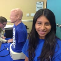 <p>Sofia Huyha, 16, learns how to identify body sounds using a stethoscope on a mannequin. </p>