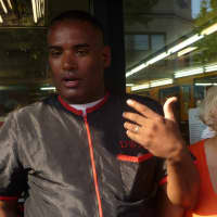 <p>William and Denise Delgado answer questions from media outside their barbershop, MasterCuts. </p>