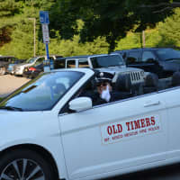<p>The driver of an old timers vehicle gives a thumbs up.</p>