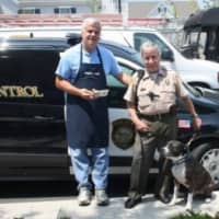 <p>Al DiGuido, president of Saugatuck Sweets (left) and Chief Westport Animal Control Officer Peter D&#x27;Amico pose with a guest of Westport Animal Control, Jack. Jack is a 3-year-old brindle bully breed mix in need of a home.</p>