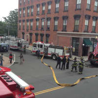 <p>Norwalk firefighters unroll hoses to fight a small apartment fire on South Main Street.</p>