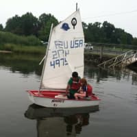 <p>Diangelo Marroquin, 11, and Priscilla Sawyer, 11, take an Optimist sailboat out as part of the Stamford Young Mariners program.</p>