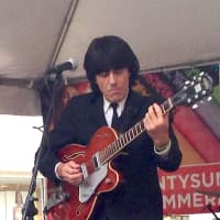 <p>A member of the Strawberry Fields band plays his vintage guitar, modeled after one of the Beatles originals. </p>