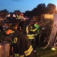 <p>Fairfield firefighters examine the rolled over FedEx tractor-trailer as the sun begins to rise. </p>